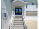 Inviting front entrance features beautiful double doors, manicured landscaping, and white staircase at 4292 Tahiti Dr, Hernando Beach, FL 34607