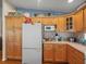 Bright kitchen featuring a refrigerator, wooden cabinets, and modern microwave at 4292 Tahiti Dr, Hernando Beach, FL 34607