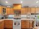Kitchen featuring wooden cabinets, tile backsplash, and a white electric range at 4292 Tahiti Dr, Hernando Beach, FL 34607