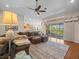 Spacious living room featuring wood floors, ceiling fan, access to the patio and kitchen in the background at 4292 Tahiti Dr, Hernando Beach, FL 34607