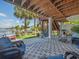 Outdoor covered patio with waterfront view, chairs, table, grill and hammock at 4292 Tahiti Dr, Hernando Beach, FL 34607