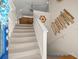 Bright staircase with neutral carpet, complemented by a ship's wheel and art at 4292 Tahiti Dr, Hernando Beach, FL 34607