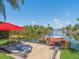 Waterfront with a dock, boat, landscaping, and outdoor seating at 4292 Tahiti Dr, Hernando Beach, FL 34607