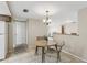 Cozy dining area with a round table, chandelier, and tile floors open to a living space at 4424 Whitetail Ln, New Port Richey, FL 34653