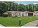 Inviting one-story home featuring lush green lawn and vibrant flowering plants in a tranquil setting at 4424 Whitetail Ln, New Port Richey, FL 34653