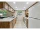 Well-lit kitchen with wooden cabinets, neutral countertops, white appliances, and a window at 4424 Whitetail Ln, New Port Richey, FL 34653