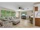 Bright living room with tiled floors, a ceiling fan, and a view into the kitchen at 4424 Whitetail Ln, New Port Richey, FL 34653