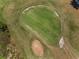 Aerial shot of a golf course showing the green, sand trap and surrounding landscape at 4485 Gevalia Dr, Brooksville, FL 34604