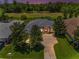 Beautiful aerial view of a gray home with a spacious driveway backing onto a lush golf course at 4485 Gevalia Dr, Brooksville, FL 34604