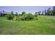 Backyard with sprawling green lawn and lush landscaping bordering the golf course at 4485 Gevalia Dr, Brooksville, FL 34604