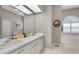 Bright bathroom featuring double sinks, soaking tub beneath arched window, and ample counter space at 4485 Gevalia Dr, Brooksville, FL 34604