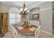 Dining area featuring a wooden table, seating for six, a chandelier, and large window with natural light at 4485 Gevalia Dr, Brooksville, FL 34604