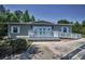 Single-story home featuring a charming white porch with double doors, white shutters, and a convenient access ramp at 4485 Gevalia Dr, Brooksville, FL 34604