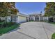 Attractive gray home featuring a spacious driveway, two-car garage, arched entry, and manicured landscaping at 4485 Gevalia Dr, Brooksville, FL 34604