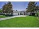 Charming home featuring a well-manicured lawn, mature trees, and inviting front entrance with arched detailing at 4485 Gevalia Dr, Brooksville, FL 34604