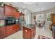An open kitchen area with stainless appliances, granite counters, central island, and dining nook with a view at 4485 Gevalia Dr, Brooksville, FL 34604