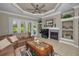 Spacious living room boasts a tray ceiling, fireplace, built-in shelving, and sliding doors for natural light at 4485 Gevalia Dr, Brooksville, FL 34604