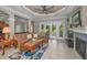 Bright living room with fireplace, leather sofa, patterned rug, and sliding doors to patio area at 4485 Gevalia Dr, Brooksville, FL 34604
