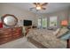 Relaxing main bedroom with a ceiling fan, carpeted floor, and a dresser with mirror at 4485 Gevalia Dr, Brooksville, FL 34604