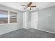 Cozy bedroom with a ceiling fan, plush carpet, and natural lighting from a nearby window at 4520 Blanche St, New Port Richey, FL 34652