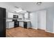 Well-lit kitchen featuring white cabinets and black appliances, with laminate floors and a subway tile backsplash at 4520 Blanche St, New Port Richey, FL 34652