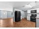 The kitchen features sleek black appliances, crisp white cabinetry, and durable wood floors at 4520 Blanche St, New Port Richey, FL 34652