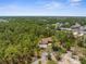 Aerial view of a well-maintained home surrounded by lush greenery and distant neighborhood at 4960 Hidden Knob Trl, Spring Hill, FL 34609