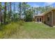 Backyard features a lawn, landscaping, and access to the home with double doors at 4960 Hidden Knob Trl, Spring Hill, FL 34609