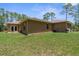 Exterior view of the backyard showcasing the lawn and the home's architectural design at 4960 Hidden Knob Trl, Spring Hill, FL 34609