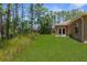 Backyard features a lawn, landscaping, and access to the home with double doors at 4960 Hidden Knob Trl, Spring Hill, FL 34609