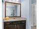 Bathroom vanity with granite countertop and dark cabinetry plus an extra large mirror at 4960 Hidden Knob Trl, Spring Hill, FL 34609