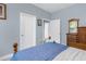 Serene bedroom with light blue walls, showcasing a charming dresser and access to other rooms at 4960 Hidden Knob Trl, Spring Hill, FL 34609