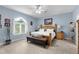 Cozy bedroom with a queen-sized bed, neutral colors, bench seating, and natural light from the window at 4960 Hidden Knob Trl, Spring Hill, FL 34609