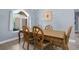Formal dining room with decorative wood table, chairs, chandelier and natural light from the window at 4960 Hidden Knob Trl, Spring Hill, FL 34609