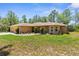 Attractive single-story home featuring manicured landscaping, arched windows, and a side-entry garage at 4960 Hidden Knob Trl, Spring Hill, FL 34609