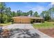 Inviting single-story home with a two-car garage, landscaping, and a concrete driveway in a wooded area at 4960 Hidden Knob Trl, Spring Hill, FL 34609