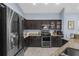 Modern kitchen equipped with stainless steel appliances, granite countertops, and dark cabinetry for a sleek design at 4960 Hidden Knob Trl, Spring Hill, FL 34609