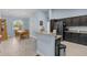 Open-concept kitchen with granite counters and bar overlooking dining area with a chandelier at 4960 Hidden Knob Trl, Spring Hill, FL 34609