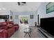 Open living room with wood-look floors, large windows, and comfortable seating area at 4960 Hidden Knob Trl, Spring Hill, FL 34609
