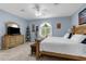 Spacious main bedroom featuring a large bed, dresser with mirror, and a bright window for natural lighting at 4960 Hidden Knob Trl, Spring Hill, FL 34609