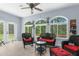 Bright sunroom with large arched windows, comfortable wicker furniture, and serene wooded views at 4960 Hidden Knob Trl, Spring Hill, FL 34609