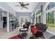 Bright sunroom with wicker furniture, plants, and large windows overlooking a lush backyard at 4960 Hidden Knob Trl, Spring Hill, FL 34609