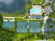 Aerial view of community pool, tennis and pickleball courts nestled near a pond and lush landscaping at 5005 Southern Valley Loop, Brooksville, FL 34601