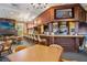 Clubhouse bar area featuring dark wood trim, liquor shelving, and a mounted flatscreen TV at 5005 Southern Valley Loop, Brooksville, FL 34601