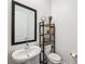 Cozy half-bathroom features a stylish pedestal sink and dark wood shelving at 5005 Southern Valley Loop, Brooksville, FL 34601
