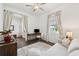 Bright bedroom features neutral colors, sleek ceiling fan, a desk, and comfortable seating at 5005 Southern Valley Loop, Brooksville, FL 34601