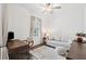 Bright bedroom features neutral colors, sleek ceiling fan, a desk, and comfortable seating at 5005 Southern Valley Loop, Brooksville, FL 34601