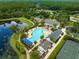 Aerial view of the community pool with winding pond, deck, lounge chairs and adjacent tennis courts at 5005 Southern Valley Loop, Brooksville, FL 34601