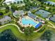 Aerial view of the refreshing community pool featuring an expansive deck, lounge chairs and clubhouse at 5005 Southern Valley Loop, Brooksville, FL 34601