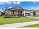 Charming single-story home featuring a manicured lawn, gray stucco, and a two-car garage at 5005 Southern Valley Loop, Brooksville, FL 34601